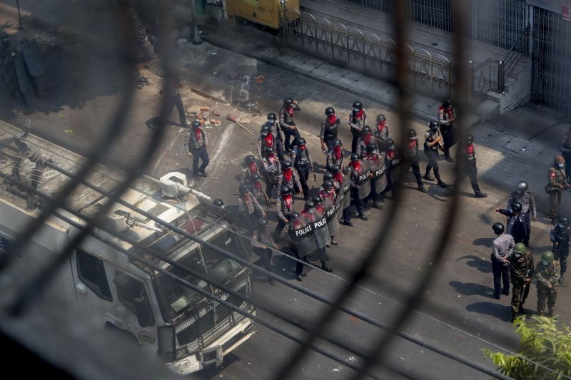 Policemen and soldiers armed with guns, sling-shots and shields advance towards anti-coup protesters in Mandalay, Myanmar on March 3, 2021. Demonstrators in Myanmar took to the streets again on Wednesday to protest last month's seizure of power by the military. (AP/PTI Photo)