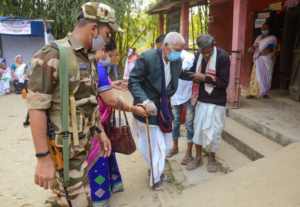 Dibrugarh: An elderly voter is helped to cast vote at a polling booth during the 1st phase of Assam Assembly elections in Lahoal constituency of Dibrugarh district, Saturday, March 27, 2021. (PTI Photo)