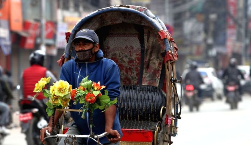 A Rickshaw driver wears mask to prevent air pollution in Kathmandu. (IANS File Photo)