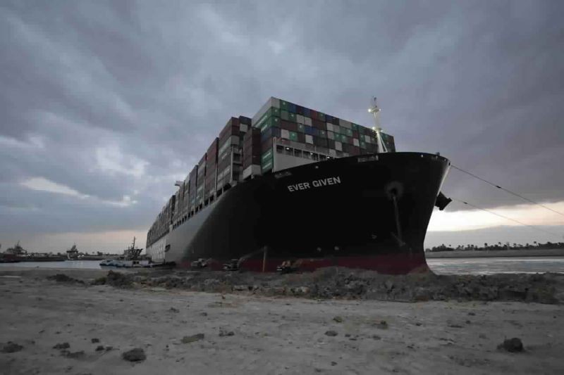 In this photo released by the Suez Canal Authority, tug boats and diggers work to free the Panama-flagged, Japanese-owned Ever Given, which is lodged across the Suez Canal on March 28, 2021. Two additional tugboats are speeding to canal to aid efforts to free the skyscraper-sized container ship wedged for days across the crucial waterway. That's even as major shippers increasingly divert their boats out of fear the vessel may take even longer to free. (AP/PTI Photo)