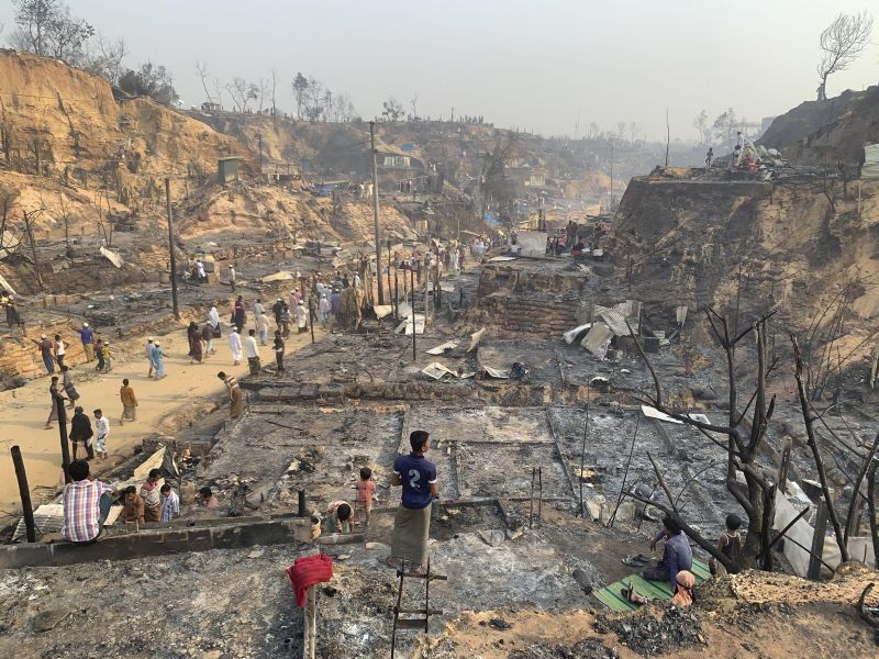 Rohingya refugees look at the remains of Monday's fire at the Rohingya refugee camp in Balukhali, southern Bangladesh, Tuesday, March 23, 2021. The fire destroyed hundreds of shelters and left thousands homeless, officials and witnesses said. (AP/PTI Photo)