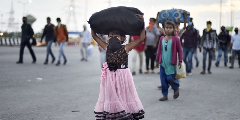 A group of migrant workers walk to their native places amid the nationwide complete lockdown, on the NH24 near Delhi-UP border in New Delhi, March 27, 2020. Photo: PTI