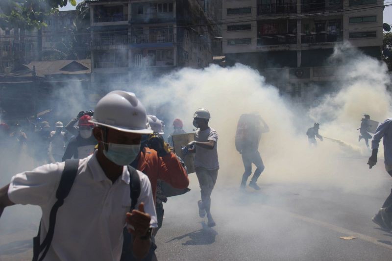 Anti-coup protesters run away from tear gas launched by security forces in Yangon, Myanmar on March 1, 2021. Defiant crowds returned to the streets of Myanmar's biggest city on Monday, determined to continue their protests against the military's seizure of power a month ago, despite security forces having killed at least 18 people around the country just a day earlier. (AP/PTI Photo)