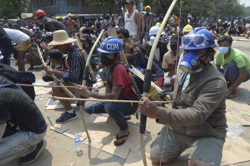 Anti-coup protesters prepare makeshift bow and arrows to confront police in Thaketa township Yangon, Myanmar, Saturday, March 27, 2021. (Photo by AP Photo/Stringer)