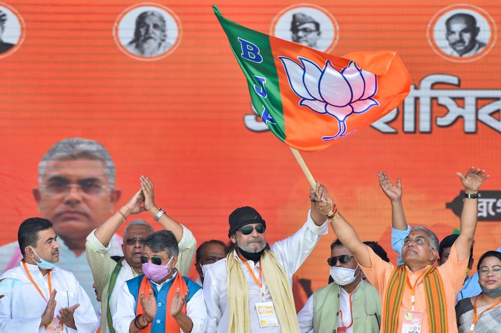 Kolkata: Bollywood actor Mithun Chakraborty along with state BJP President Dilip Ghosh holds the party flag after he joined the party during a public meeting ahead of West Bengal Assembly Polls, at Brigade Parade Ground in Kolkata, Sunday, March 7, 2021. (PTI Photo/Swapan Mahapatra)