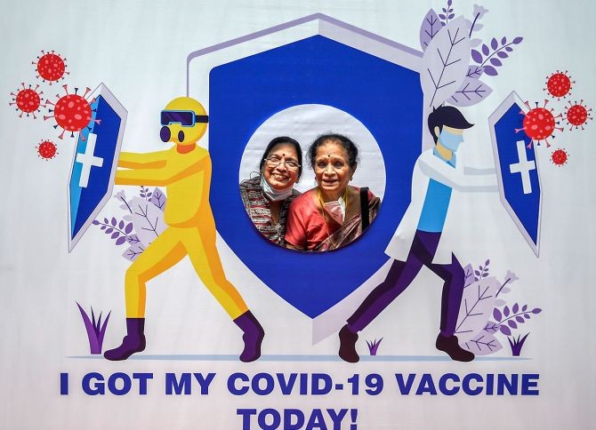 Senior citizens pose for photographs with a cut-out on being administered the COVID-19 vaccine at a paid centre at SRCC Hospital in Mumbai. Photograph: Kunal Patil/PTI Photo