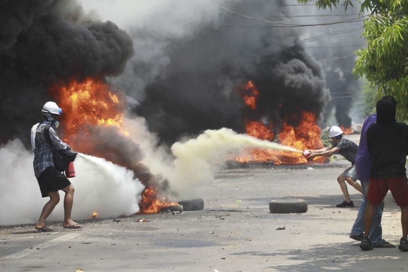 Yangon: Anti-coup protesters extinguish fires during a protest in Thaketa township Yangon, Myanmar, Saturday, March 27, 2021.(AP/PTI Photo)