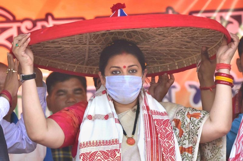 Nagaon: Union Minister of Textiles Smriti Irani being presented an 'Assamese Japi' by party leaders during a public meeting in support of the party candidate Anil Saikia ahead of state assembly polls, at Ambagan in Nagaon District of Assam, Saturday, March 13, 2021. (PTI Photo)