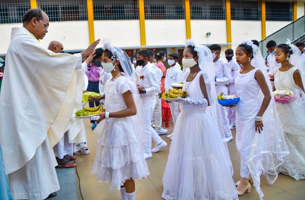Ranchi: Newly oath taking under-age students belonging to Christian community participated in 'White Sunday' as their first 'Prasad' received by Church during an special prayer in Church in Ranch, Sunday, April 11, 2021. The day is for parents and communities to acknowledge and celebrate childhood by hosting special programs during church services which include scriptural recitations, biblical story reenactments, and creative dance performances. (PTI Photo) 