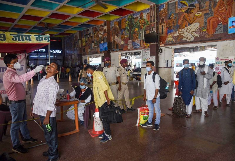 A health worker takes a swab sample from a passenger for COVID-19 test at Patna junction, in Patna on April 8, 2021. (PTI Photo)