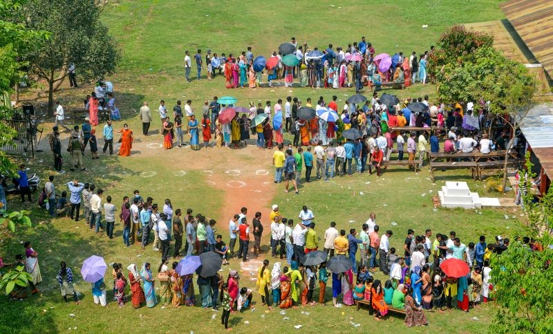 Voters queue up to cast their votes at a polling station, during the third and final phase of Assam Assembly election, in Guwahati on April 6. (PTI Photo)
