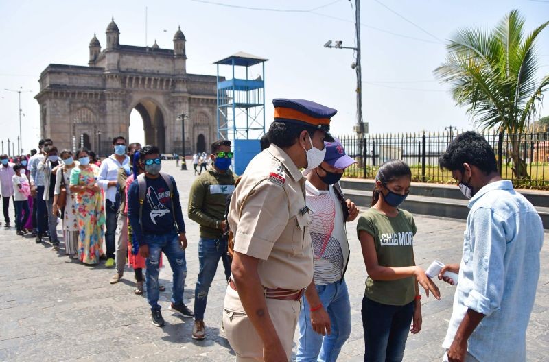 People queue up as they wait for their turn to undergo a mandatory COVID-19 test before entering the Gateway of India, in Mumbai on April 4. (PTI Photo)