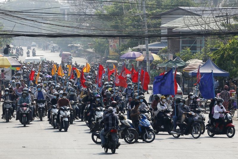 Protesters carry flags as they drive their motorcycles during an anti-coup protest in Mandalay, Myanmar on March 25, 2021. Protesters against last month's military takeover in Myanmar returned to the streets in large numbers Thursday, a day after staging a "silence strike" in which people were urged to stay home and businesses to close for the day. (AP/PTI File Photo)