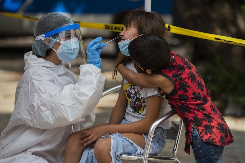 Montevideo: A boy embraces his sister as a healthcare worker swabs his sister's nose for a sample to test for COVID-19 in Montevideo, Uruguay, Thursday, April 15, 2021. AP/PTI
