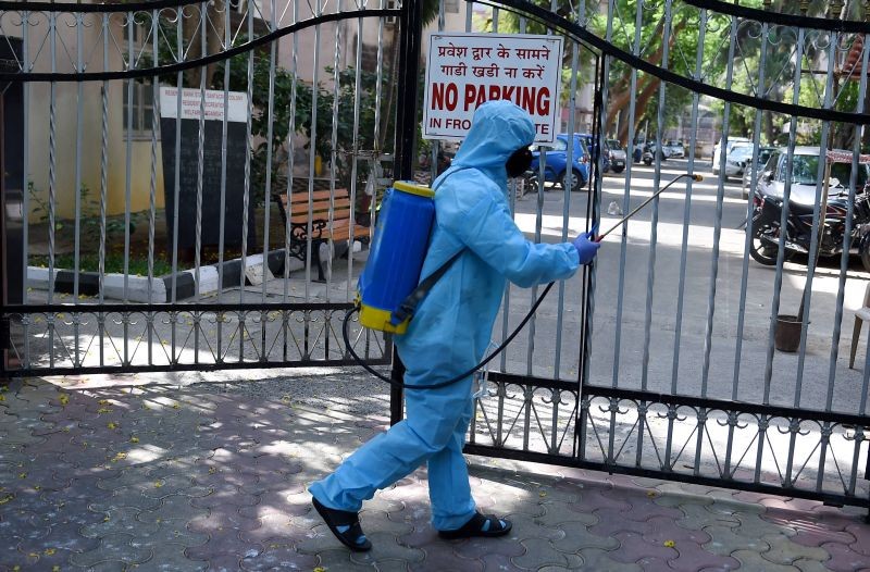 A worker sanitises an area outside a residential complex as a precautionary measure against COVID-19, in Mumbai on April 6, 2021.(PTI Photo)