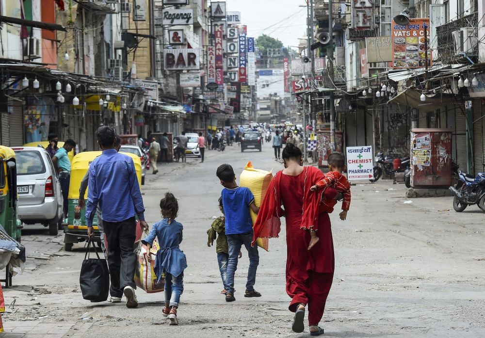 New Delhi: A family walks through a market, closed in view of Covid-induced lockdown, in Pahargunj area of New Delhi, Tuesday, April 20, 2021. (PTI Photo/Kamal Singh)