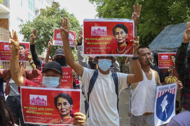 Anti-coup protesters flash the three-fingered symbol of resistance while holding slogans bearing pictures of deposed leader Aung San Suu Kyi during a demonstration in Yangon, Myanmar on April 7, 2021. Threats of lethal violence and arrests of protesters have failed to suppress daily demonstrations across Myanmar demanding the military step down and reinstate the democratically elected government. (AP/PTI Photo)