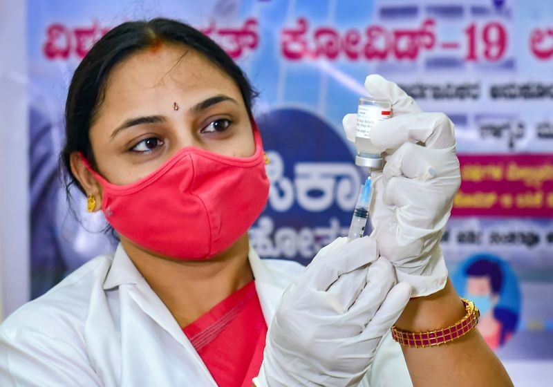 A medic prepares to administer the first dose of COVID-19 vaccine to a woman during the vaccination festival 'Tika Utsav', at Atal Bihari Vajpayee Medical College & Research Centre in Bengaluru, on April 11, 2021. (PTI Photo)