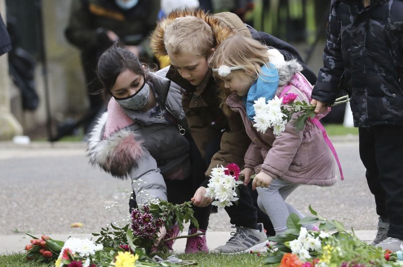 Children arrive to leave flowers at Cambridge Gate, at Windsor Castle, one day after the death of Britain's Prince Philip, in Windsor, England on April 10, 2021. Britain's Prince Philip, the irascible and tough-minded husband of Queen Elizabeth II who spent more than seven decades supporting his wife in a role that mostly defined his life, died on Friday. (AP/PTI Photo)