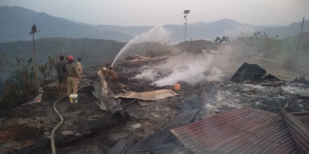 Fire personnel can be seen fighting  the fire at a village in Mon district.