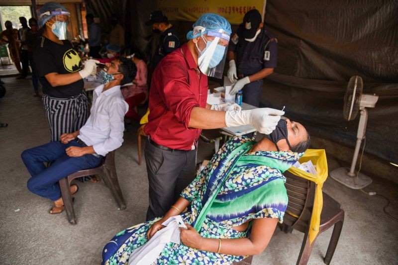 Medics from Navi Mumbai Municipal Corporation (NMMC) collect swab sample of traders and workers for COVID-19 tests, at APMC Turbhe in Navi Mumbai on April 9. (PTI Photo)