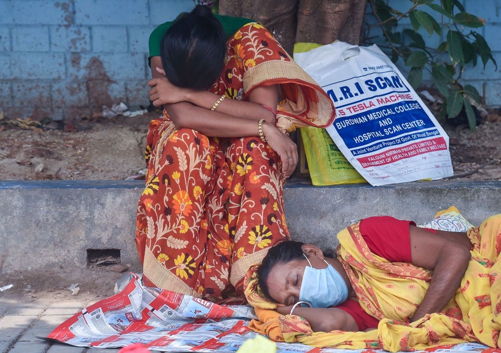Kolkata: Family of a COVID-19 patient rest outside a government run hospital, facing shortage in beds and medical oxygen, as coronavirus case surge in record numbers across the country, in Kolkata, Thursday, April 22, 2021. (PTI Photo/Swapan Mahapatra)