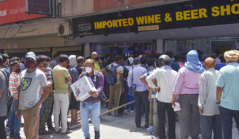 People gather in large numbers outside liquor shop after lockdown  announcement in National Capital, in New Delhi on April 19. (PTI Photo)