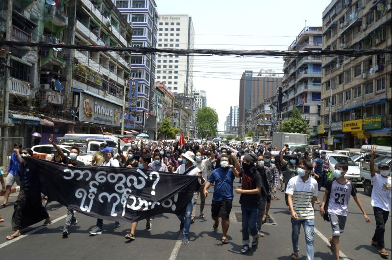 Anti-coup protesters march on a street with banner read " What we are? We are Yangon! People!",  during a demonstration in Yangon, Myanmar on April 23, 2021. Leaders of the 10-member Association of Southeast Asian Nations meet Saturday, April 24, in Jakarta to consider plans to promote a peaceful resolution of the conflict that has wracked Myanmar since its military launched a deadly crackdown on opponents to its seizure of power in February. (AP/PTI Photo)