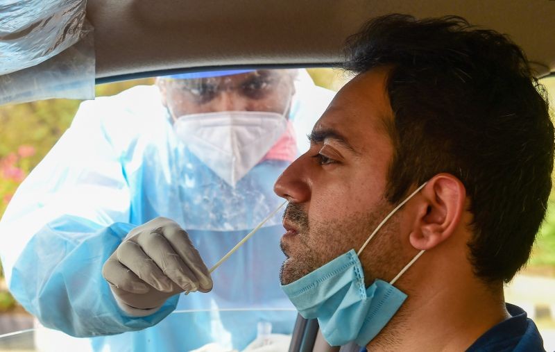 A health worker collects samples of a motorist for Covid-19 tests, as coronavirus cases spike across the country, in New Delhi on April 5, 2021. (PTI Photo)