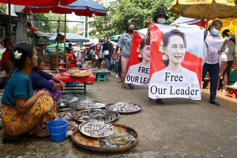 Anti-coup protesters walk through a market with images of ousted Myanmar leader Aung San Suu Kyi at Kamayut township in Yangon, Myanmar on April 8, 2021. They walked through the markets and streets of Kamayut township with slogans to show their disaffection for military coup.  (AP/PTI Photo)