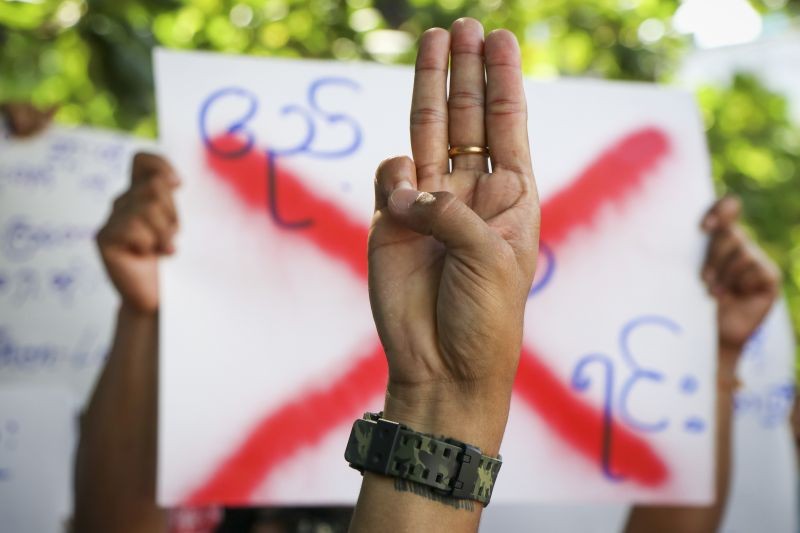 An anti-coup protester shows the three fingered salute of resistance during a strike walk with slogans to show their disaffection for military coup at neighborhood area of Hlaing township in Yangon, Myanmar, Friday, April 9, 2021. Threats of lethal violence and arrests of protesters have failed to suppress daily demonstrations across Myanmar demanding the military step down and reinstate the democratically elected government. (Photo by AP Photo/Stringer)
