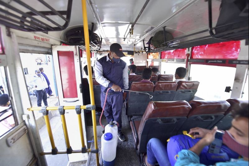 A worker sanitizes a bus at ISBT Anand Vihar,  during weekend lockdown imposed in the wake of rising Covid-19 cases across the country, in New Delhi on April 17, 2021. (PTI Photo)