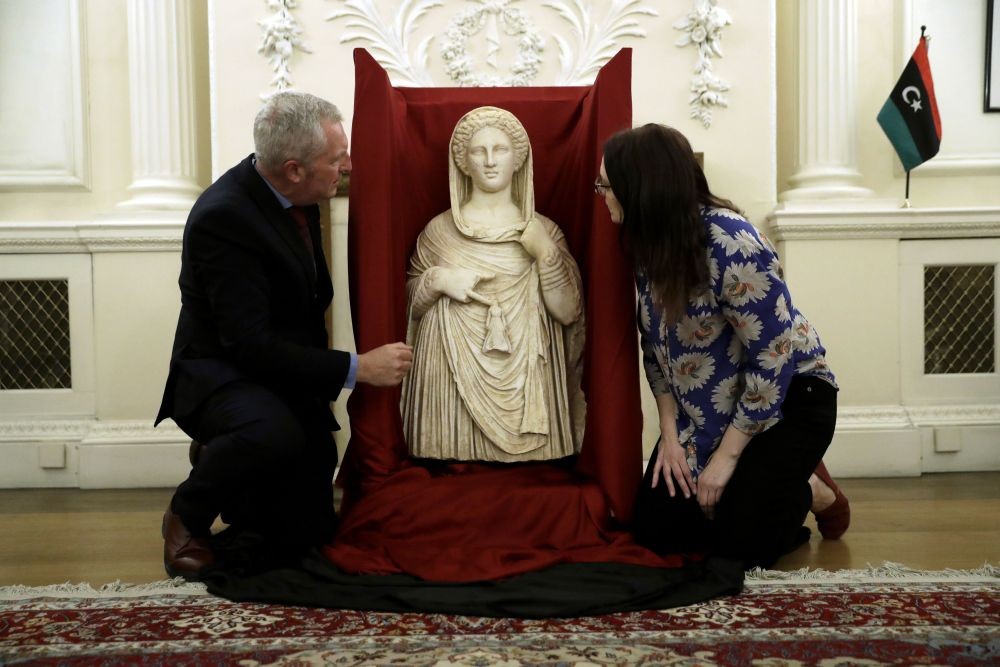 London: British Museum's Peter John Higgs, left, and museum member of staff Hannah Boulton pose next to a 2nd century BC funerary statue from the ancient Greek city of Cyrene, thought to represent either the goddess Demeter or more likely her daughter Persephone, at the Libyan Embassy in London, Monday, May 10, 2021. The statue was returned to the Libyan embassy in April after being temporarily stored at the British Museum after it was seized several years ago by British Border Force officials at Heathrow airport in London, having been illicitly imported into Britain to be offered for sale. AP/PTI