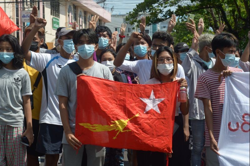 Anti-coup protesters hold the flag of the National League of Democracy party of ousted Myanmar leader Aung San Suu Kyi, while others flash the three-fingered salute during a "flash mob" rally in Bahan township in Yangon, Myanmar on May 9, 2021. Myanmar's junta has labeled a shadow government of lawmakers and politicians ousted in a February coup and a people's defense force that is being set up to confront security forces as terrorist groups. (AP/PTI Photo)