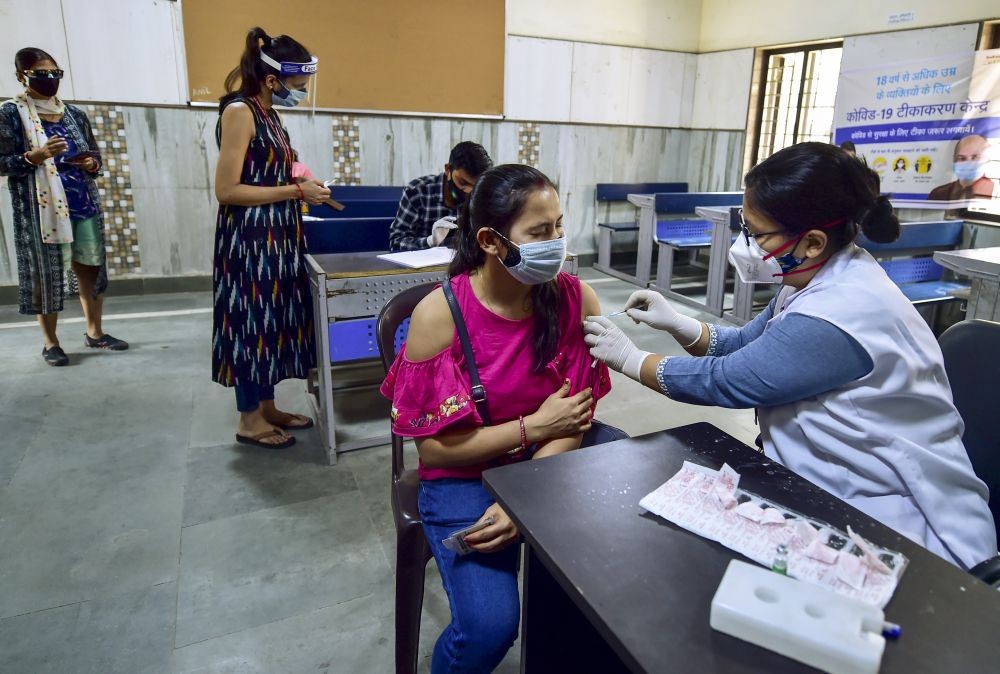 New Delh: A medic administers the first dose of COVID-19 vaccine to young beneficiary at a vaccination centre in a govt school, in New Delhi, Monday, May 3, 2021.  The third phase of the inoculation drive (18-45yrs) of vaccines began today. (PTI Photo/Manvender Vashist)