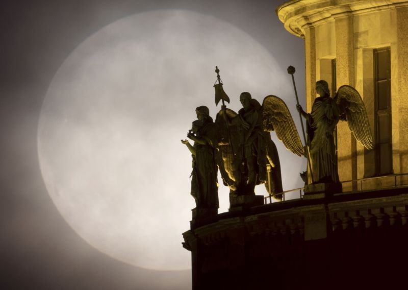 St. Petersburg:Sculptures of angels on the St. Isaac's Cathedral are silhouetted on the full moon rising in the clouds in St. Petersburg, Russia, Wednesday, May 26, 2021.AP/PTI Photo.