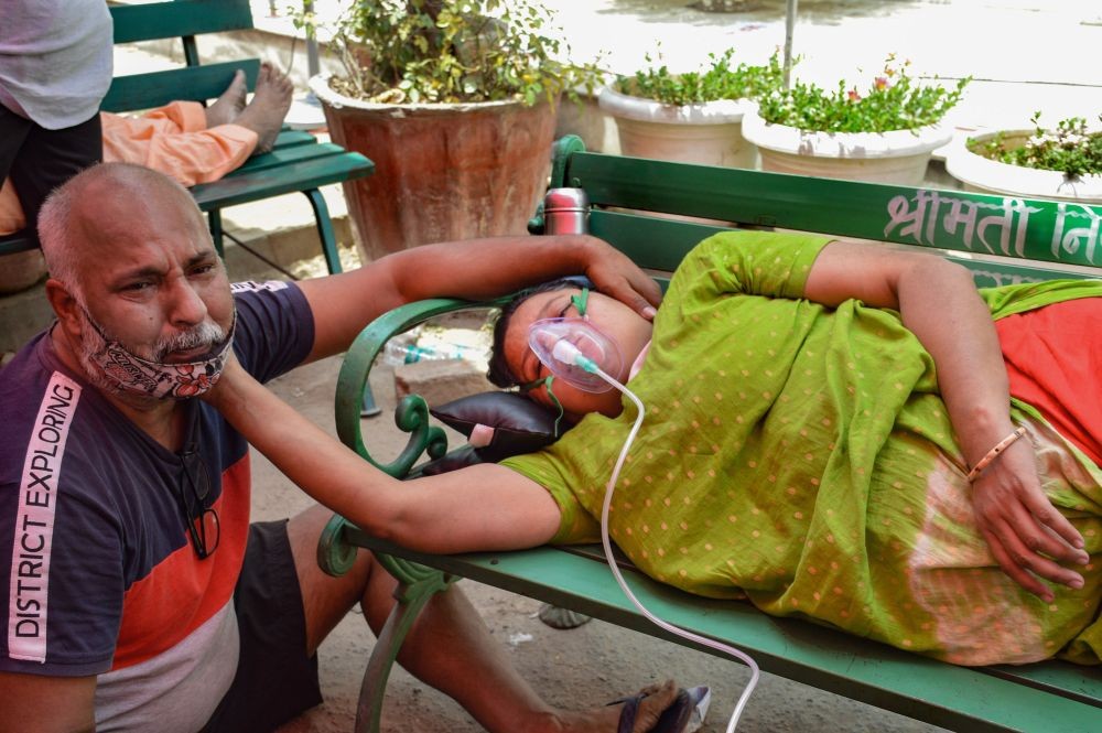Ghaziabad: Mukesh sits near his wife a she gets free oxygen, provided by a Sikh organization at Indirapuram Gurdwara for Covid-19 patients, in Ghaziabad, Monday, May 3, 2021. (PTI Phot0)