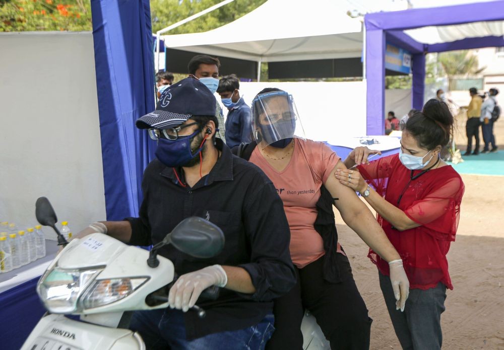 Ahmedabad: Health worker gives a dose of COVID-19 vaccine at a drive-through vaccination centre in Ahmedabad, Thursday, May 13, 2021. (PTI Photo)