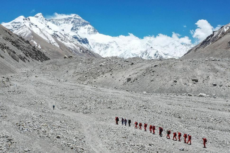 FILE - In this May 16, 2020, file photo released by Xinhua News Agency, Chinese surveyors hike toward a higher spot from the base camp on Mount Qomolangma at an altitude of 5,200 meters. China has opened the spring Everest claiming season from the northern approach amid strict measures to prevent the spread of COVID-19. A total of 38 people have been issued permits to climb the world’s highest peak, known as Qomolongma in Tibetan, between March 31 and May 20, state media reported Friday, May 7, 2021. (Jigme Dorje/Xinhua via AP, File) THE ASSOCIATED PRESS
