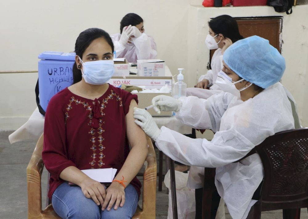 Jammu: A medical worker inoculates a young woman with a dose of COVID-19 vaccine, at a vaccination centre in Jammu, Friday, May 7, 2021. (PTI Photo)