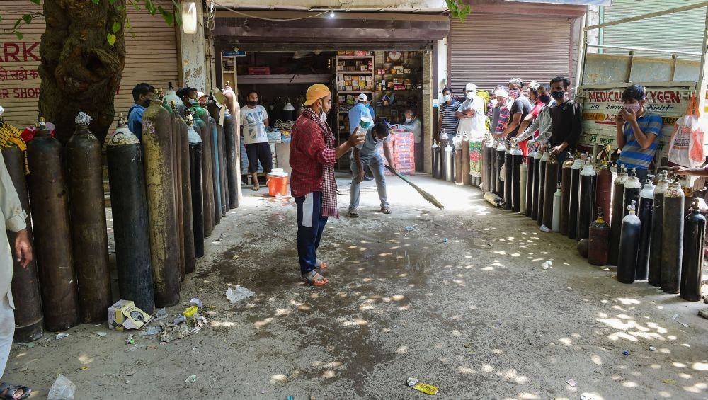 New Delhi: Family members of COVID-19 patients wait outside an oxygen-filling centre to refill their empty cylinders, as demand for the gas rises due to spike in coronavirus cases, in New Delhi Monday, May, 3, 2021. (PTI Photo/Kamal Kishore)