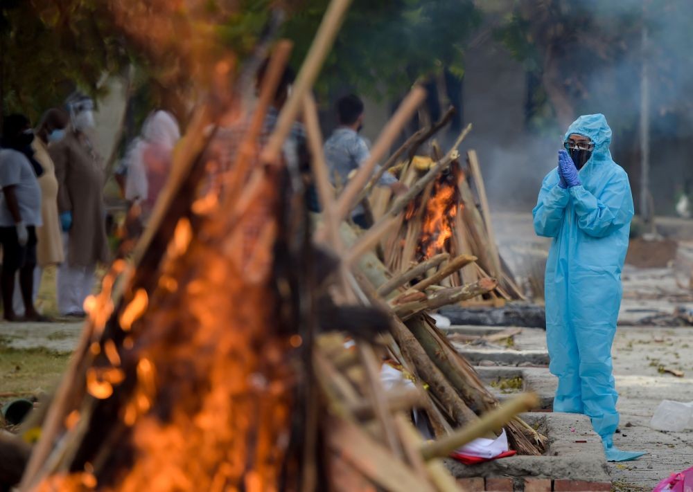 New Delhi: A family member conducts last rites  before cremation of a person who died of COVID-19, at Sarai Kale Khan Cremation Ground in New Delhi, Thursday, May 6, 2021.  (PTI Photo/Manvender Vashist)
