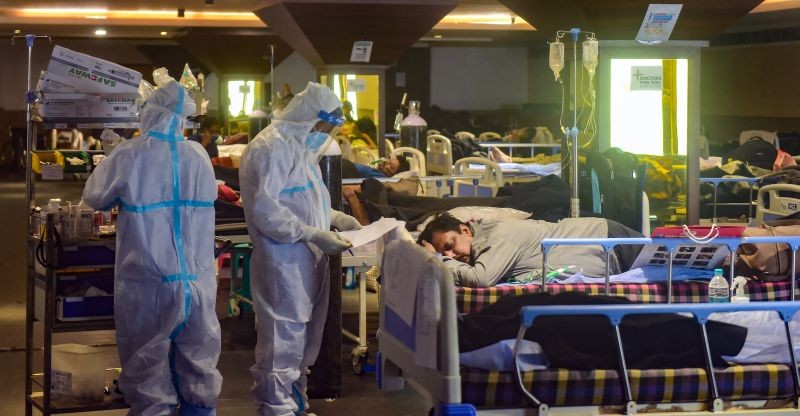 Health workers inspect COVID-19 patients undergoing treatment at Shehnai Banquet Hall, converted into an isolation centre amid surge in coronavirus cases, near LNJP Hospital in New Delhi on May 5, 2021. (PTI Photo)