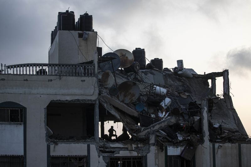 A Palestinian searches for survivors under the rubble of a destroyed rooftop of a residential building which was hit by Israeli missile strikes, at the Shati refugee camp in Gaza City, early Tuesday, May. 11, 2021. (AP/PTI Photo)