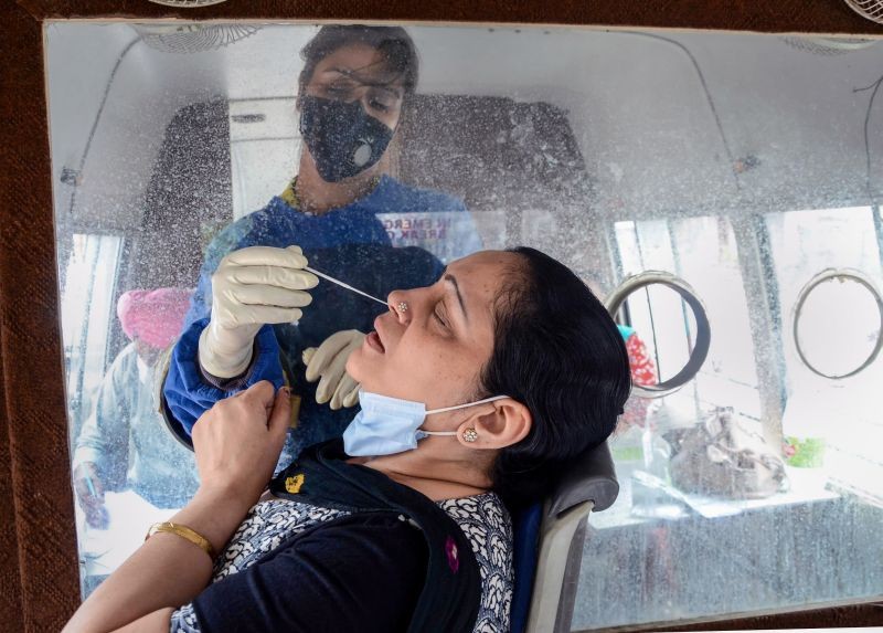 A medic takes swab sample of a woman for COVID-19 test, from a mobile van, in Amritsar on May 5, 2021. (PTI Photo)