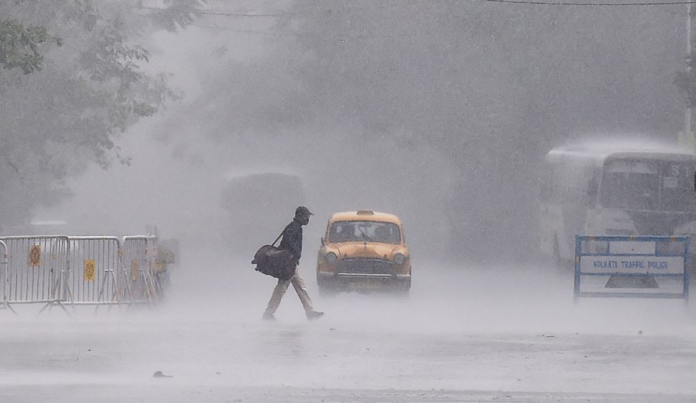 Kolkata: A man crosses a city street during sudden rain in Kolkata, Sunday, May 9, 2021. (PTI Photo/Swapan Mahapatra)