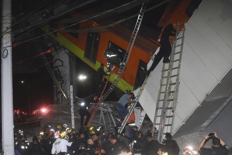 Mexico City fire fighters and rescue personnel work to recover victims from a subway car that fell after a section of Line 12 of the subway collapsed in Mexico City, Monday, May 3, 2021. The section passing over a road in southern Mexico City collapsed Monday night, dropping a subway train, trapping cars and causing at least 50 injuries, authorities said. (AP Photo)