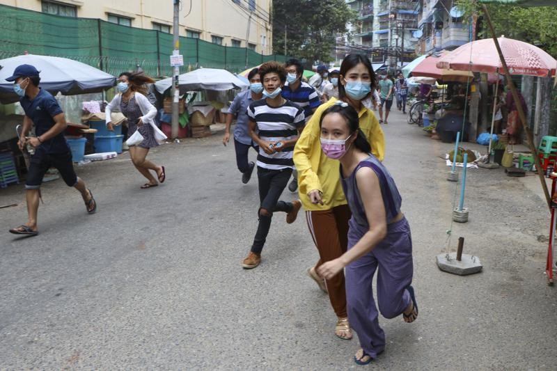 Anti-coup protesters run after seeing police and soldiers arrive to disperse their demonstration in Yangon, Myanmar, Tuesday, April 27, 2021. (AP Photo)