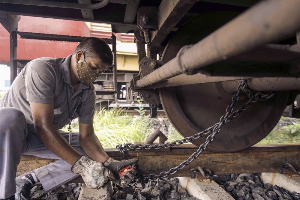 Howrah: A railway worker ties a train with its tracks using chains as part of preparations for Cyclone Yaas, at Shalimar Station in Howrah, Monday, May 24, 2021. (PTI Photo)