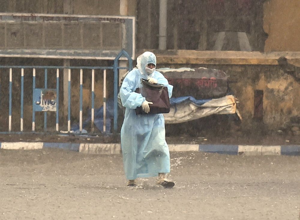 Kolkata:A health worker wearing PPE suit returns home after her duty from a Covid hospital during heavy rain in Kolkata, Tuesday, May 11, 2021. (PTI Photo/Swapan Mahapatra)